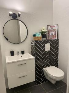 a bathroom with a white toilet and a mirror at LE POP ART Studio-Proche tram in Gaillard