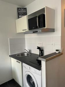 een keuken met een wastafel en een wasmachine bij LE POP ART Studio-Proche tram in Gaillard