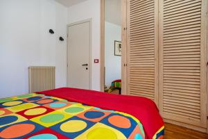 - une chambre avec un lit et une couverture colorée dans l'établissement Balconi Rossi Borgo Valsugana, à Borgo