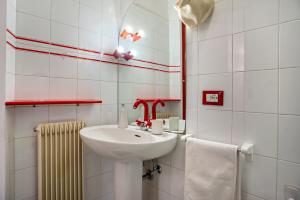 a white bathroom with a sink and a mirror at Balconi Rossi Borgo Valsugana in Borgo +27 photos