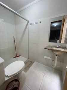 a white bathroom with a toilet and a sink at Pousada da Nicole in Canindé de São Francisco