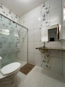 a bathroom with a toilet and a glass shower at Pousada da Nicole in Canindé de São Francisco