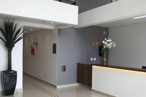 a lobby with a potted plant and a reception desk at Lindo Studio na Av Kennedy SCS in São Caetano do Sul