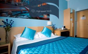 a bedroom with a bed with blue pillows at Daplace - La Mongolfiera Rooms in Navona in Rome