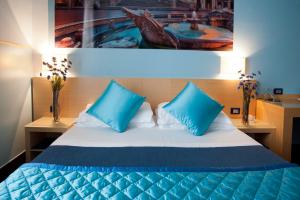Un dormitorio con una cama azul y blanca con almohadas azules en Daplace - La Mongolfiera Rooms in Navona, en Roma