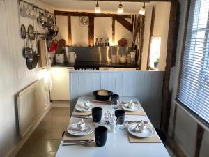 a table with dishes on it in a kitchen at Black Sheep Cottage in Saxmundham