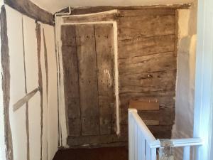 an old wooden door in a room with stairs at Black Sheep Cottage in Saxmundham