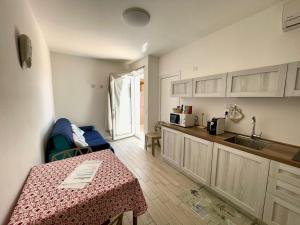 a kitchen with a table and a counter top at Appartamenti Renzo&Rita2 Carmelina in SantʼAntìoco
