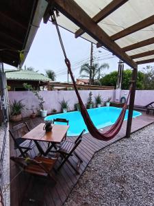un patio con una hamaca y una piscina en Refúgio Moçambique, en Florianópolis