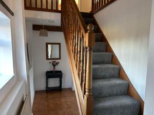 a stairway with a wooden rail and a stair case at The Byre in Lichfield