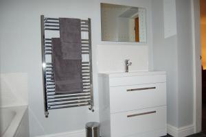 a white bathroom with a sink and a mirror at Anneddle Cottage in Talybont, near Barmouth in Talybont