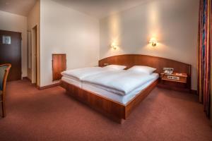 Schlafzimmer mit einem großen Bett mit einem Kopfteil aus Holz in der Unterkunft Hotel Alte Wache in Hamburg