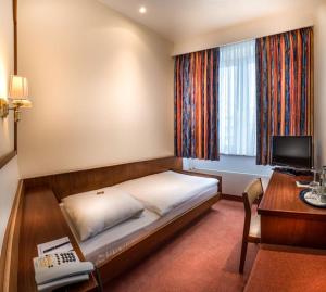 1 dormitorio con 1 cama y escritorio con ordenador en Hotel Alte Wache en Hamburgo