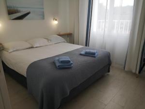 um quarto com uma cama com duas toalhas em APPARTEMENTS- Place Alexandres 4 Vents em Asnelles