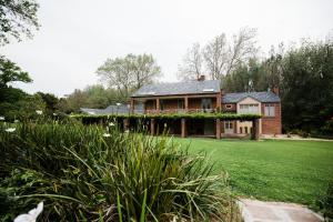 uma casa grande com um quintal com um campo de relva em Marshden Estate em Stellenbosch