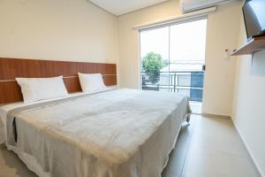 a bedroom with a large bed with a large window at VIVARIUM APART HOTEL in Asunción