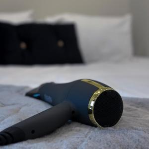 a hair dryer sitting on top of a bed at Cosy Central Bedford Apt - Free Parking, Gym, Netflix & Sky in Bedford