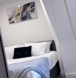 a bedroom with a bed with white sheets and pillows at Cosy Central Bedford Apt - Free Parking, Gym, Netflix & Sky in Bedford