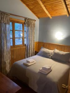 1 dormitorio con 1 cama con 2 toallas en Cabañas Parque Almendro, en San José de Maipo