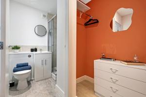 an orange bathroom with a toilet and a sink at Stockport Retreat - Double En-suite - Great transport links - Greater Manchester in Stockport