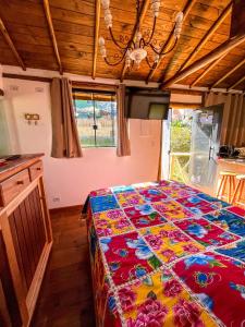 a bedroom with a large bed with a colorful quilt at Chalé dos Açaís próximo à Trindade in Paraty