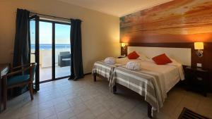 Ліжко або ліжка в номері Hotel Avenida Praia