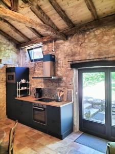 a kitchen with a stove top oven next to a window at La Framie basse in Albas