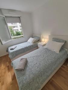 1 dormitorio con 2 camas y ventana en Appartement lumineux, en Saint-Denis