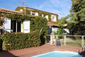 an ivy covered house with a swimming pool at Maison d'hote villa monique in Cuges-les-Pins