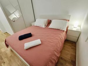 a bedroom with a bed with two pillows on it at Appartement lumineux in Saint-Denis