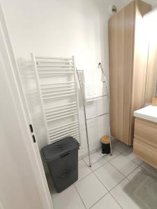 un pequeño baño blanco con un cubo de basura. en Appartement lumineux, en Saint-Denis