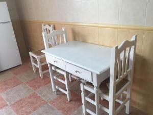 cocina con mesa blanca y 4 sillas en El Mirador de Sierra Mágina, 