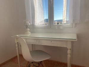 - un bureau blanc avec une chaise devant une fenêtre dans l'établissement El Mirador de Sierra Mágina, 
