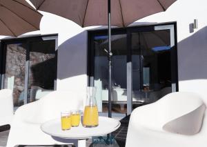 Igrejinha的住宿－MyStay - Casa de Baco，桌子上放着两杯橙汁,上面放着一把雨伞