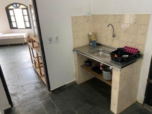 a kitchen with a sink next to a refrigerator at Suítes Temporada Favorita in Peruíbe