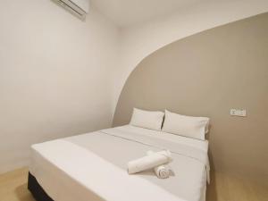 un letto con lenzuola e cuscini bianchi in una stanza di ₘₐcₒ ₕₒₘₑ【Private Room】@Stulang 【CIQ】【Mid Valley】 a Johor Bahru