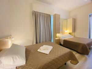 Habitación de hotel con 2 camas y espejo en Hotel Butterfly, en Rímini