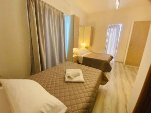a small room with two beds and a mirror at Hotel Butterfly Wellness & Spa in Rimini