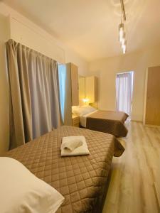 a hotel room with two beds and a window at Hotel Butterfly Wellness & Spa in Rimini