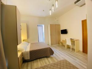 a bedroom with a bed and a desk and a table at Hotel Butterfly Wellness & Spa in Rimini