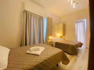 a hotel room with two beds and a window at Hotel Butterfly Wellness & Spa in Rimini