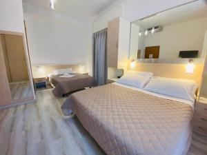 a hotel room with a large bed and a mirror at Hotel Butterfly Wellness & Spa in Rimini