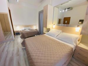 a hotel room with a large bed and a mirror at Hotel Butterfly Wellness & Spa in Rimini