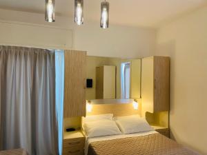 a bedroom with a bed and a mirror at Hotel Butterfly Wellness & Spa in Rimini