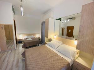 a hotel room with a bed and a mirror at Hotel Butterfly Wellness & Spa in Rimini