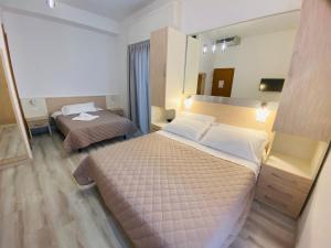 a hotel room with two beds and a mirror at Hotel Butterfly Wellness & Spa in Rimini
