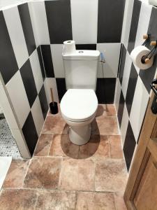 a bathroom with a toilet with a tile floor at La Framie basse in Albas