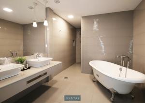 Igrejinha的住宿－MyStay - Casa de Baco，浴室配有两个盥洗盆和浴缸。