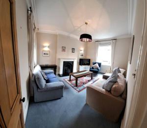 a living room with two couches and a fireplace at Stunning 3BD Victorian House in Bramhall Village in Bramhall