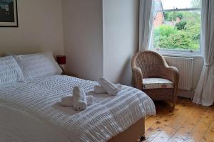 ein Schlafzimmer mit einem Bett, einem Stuhl und einem Fenster in der Unterkunft Stunning 3BD Victorian House in Bramhall Village in Bramhall